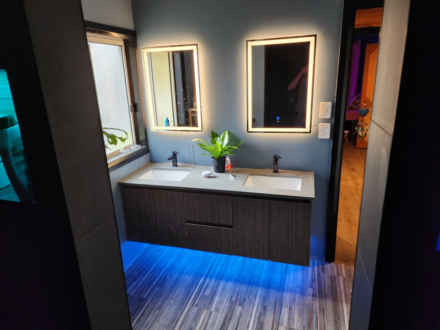 Bathroom with illuminated mirror and under-vanity feature lighting